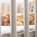 Bébé endormi dans son lit à barreaux