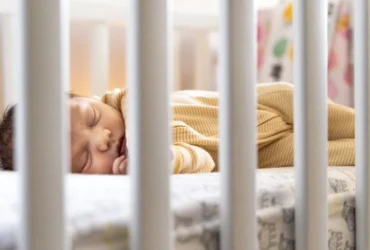 Bébé endormi dans son lit à barreaux